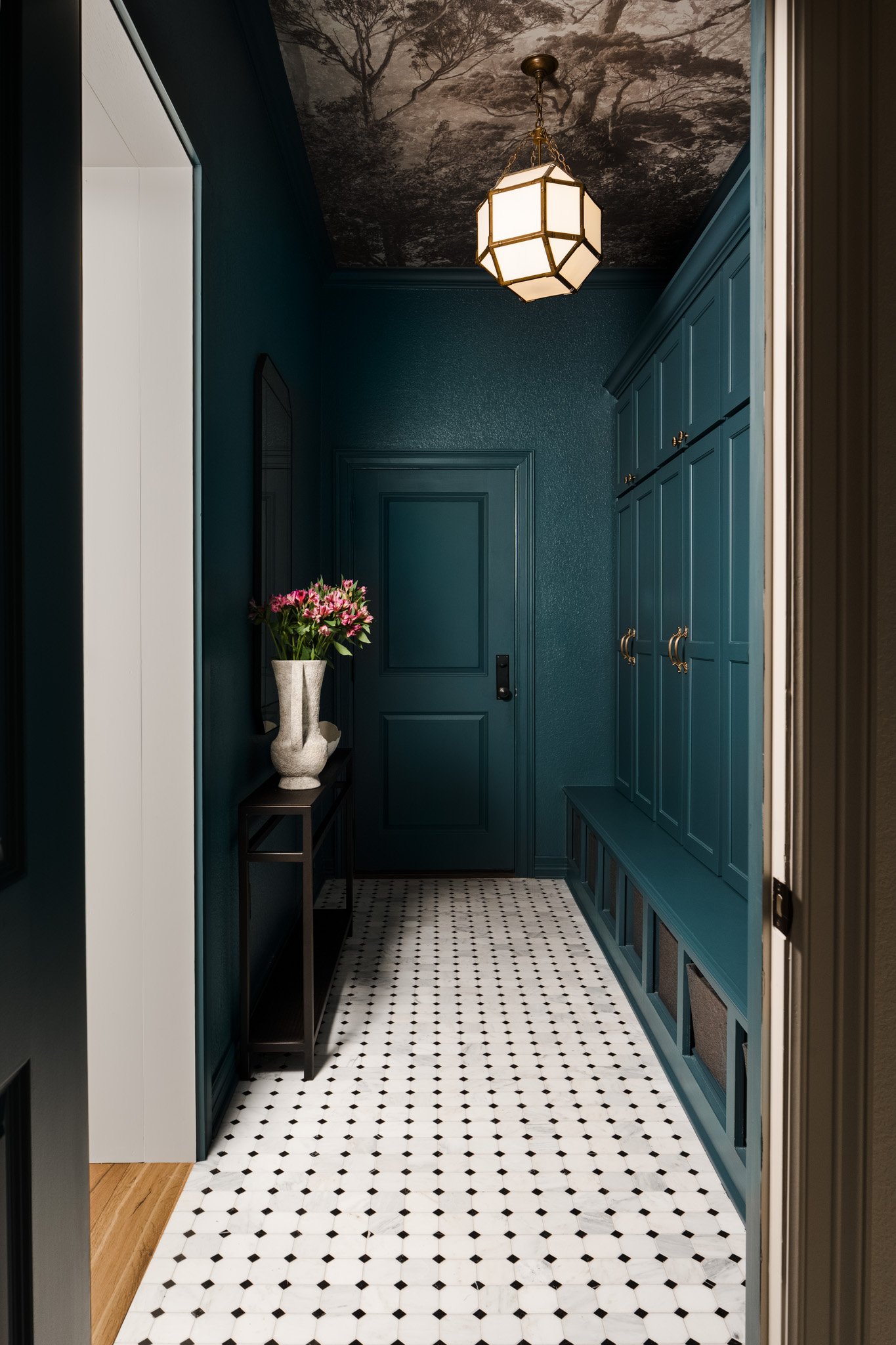 Moody teal hallway with paneled walls and patterned tile floor. Design by Brittney Lane Interiors 