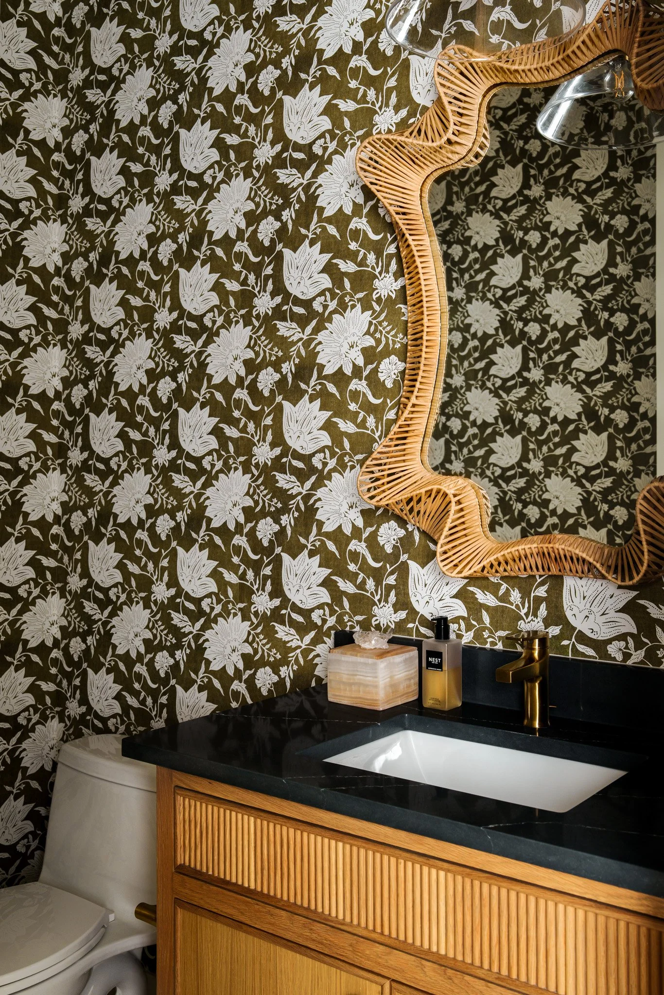 Powder bathroom with floral wallpaper and sculptural mirror. Design by JRZ Designs 