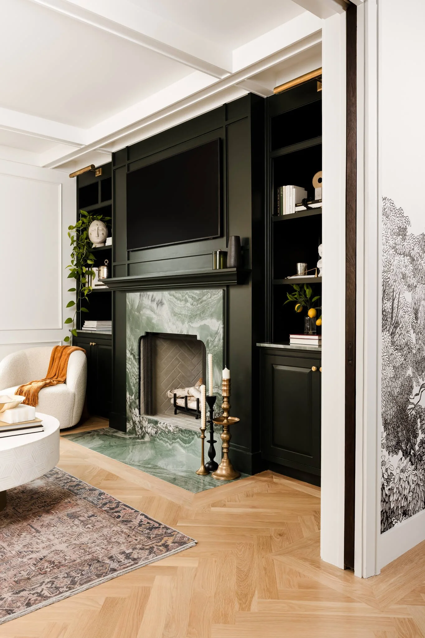 Dark green marble fireplace with custom black built-ins and layered styling photographed for an interior design project in Dallas.