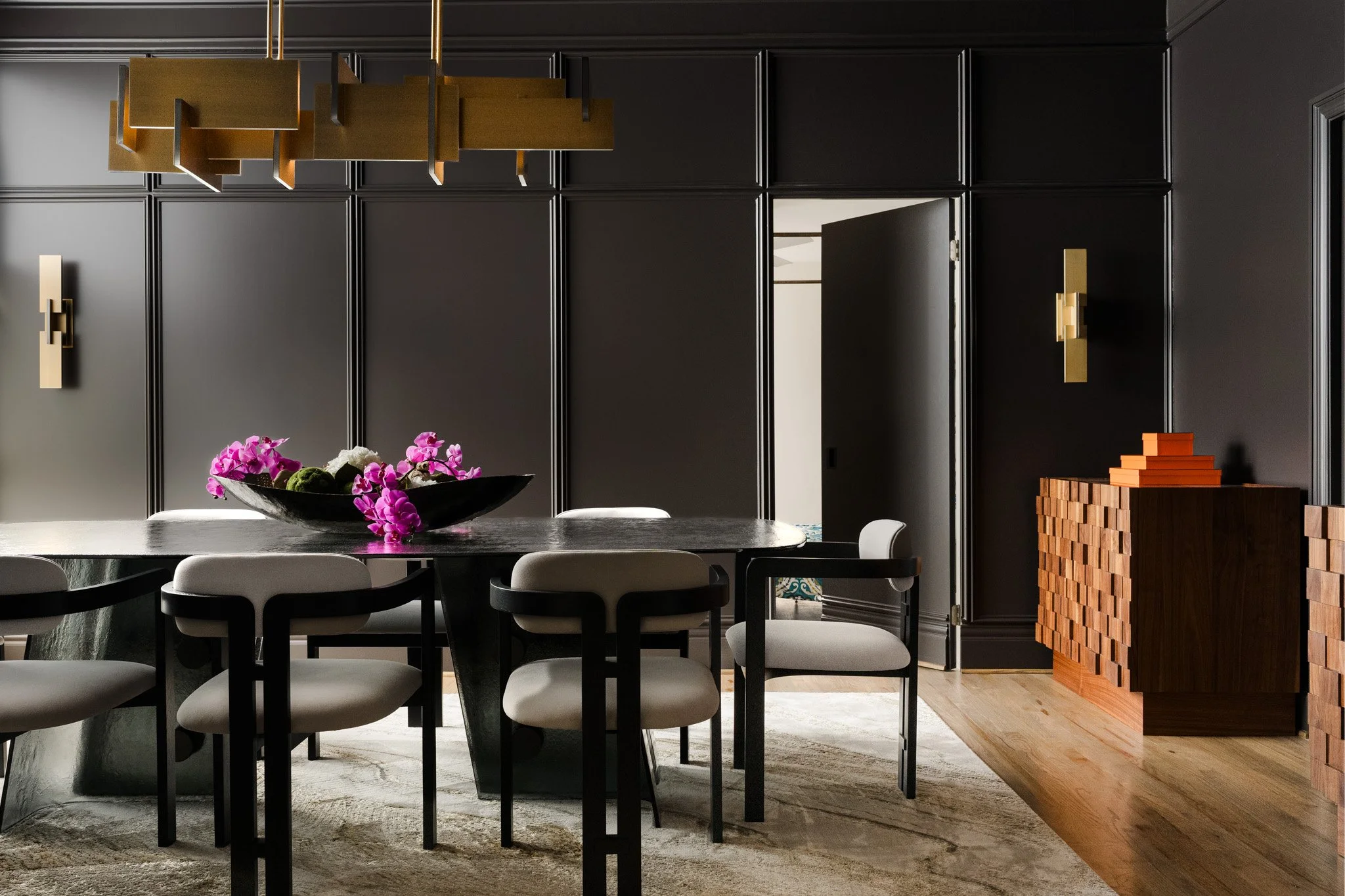 modern moody dining room with brass chandelier texas interior photography