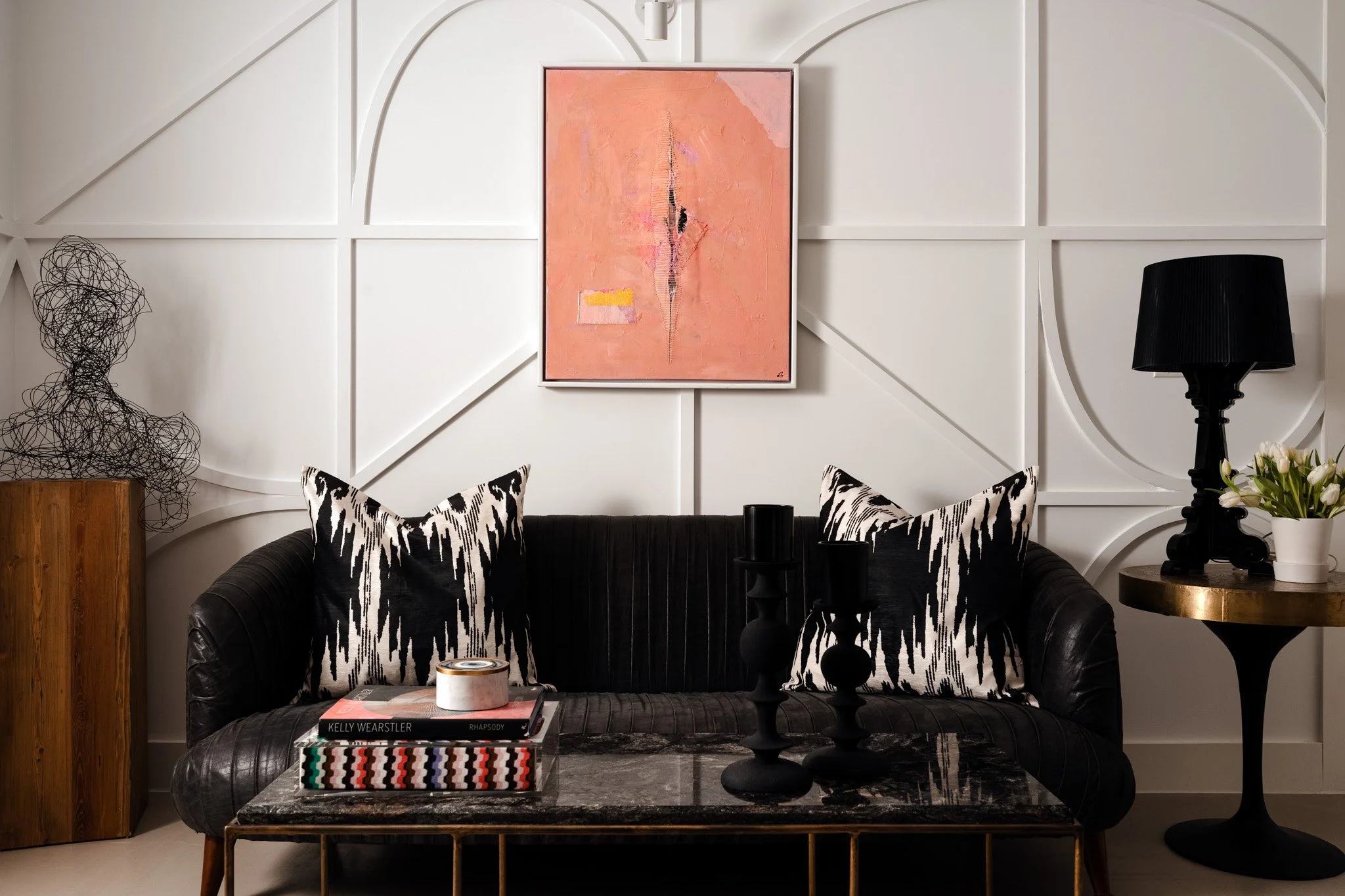 Black leather sofa with sculptural decor and modern artwork