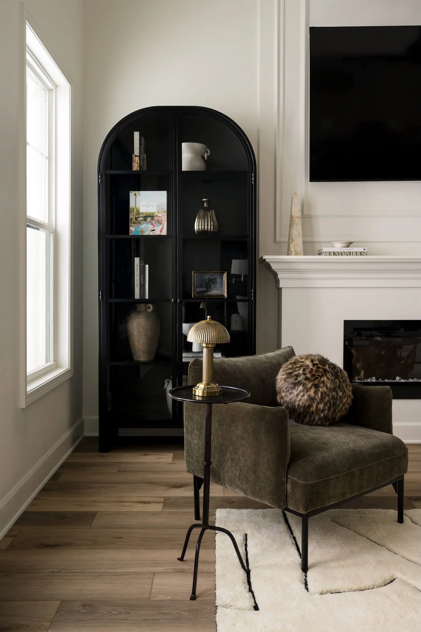 Cozy reading nook with velvet chair and black arched bookcases Austin interior photographer.