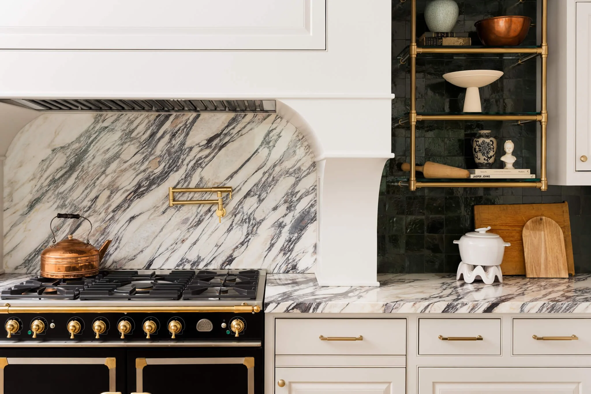 ditorial kitchen detail featuring marble backsplash, brass hardware, and luxury black range in a modern Texas home.