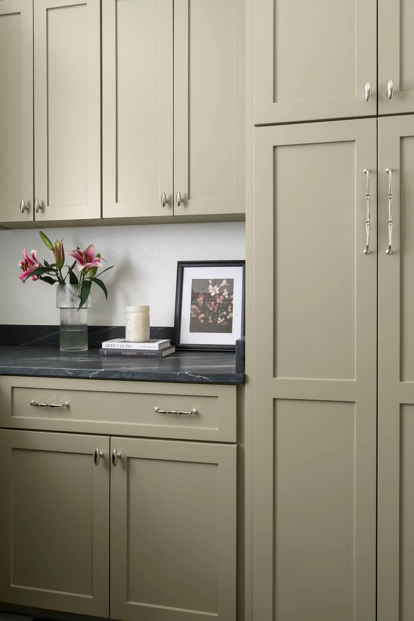 Rustic laundry room with army green cabinetry, soapstone counters, and checkered tile floor