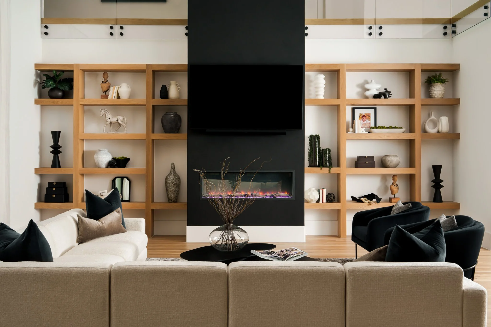 Living room with custom wood shelving and modern fireplace. Design by Travis Pernell Interiors and Kea Interiors 
