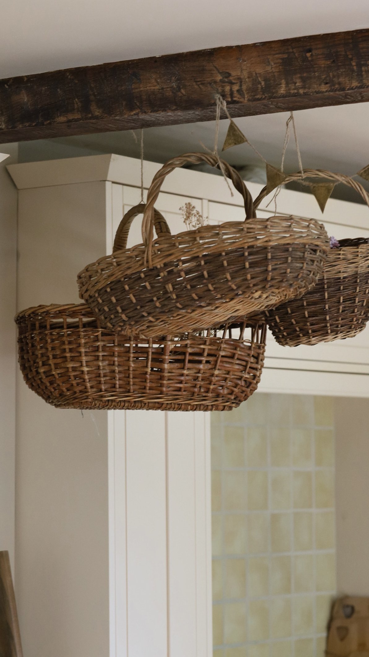 Rustic French wicker basket hanging from a beam