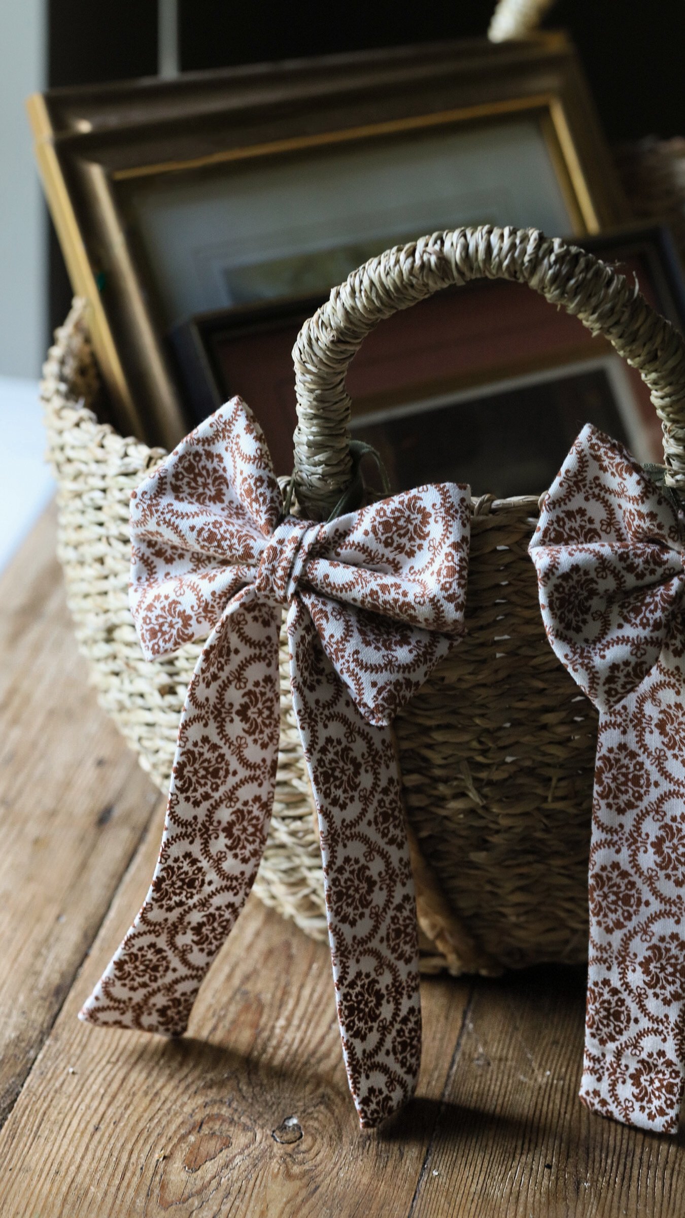 Vintage fabric basket bow attached to a rustic basket handle