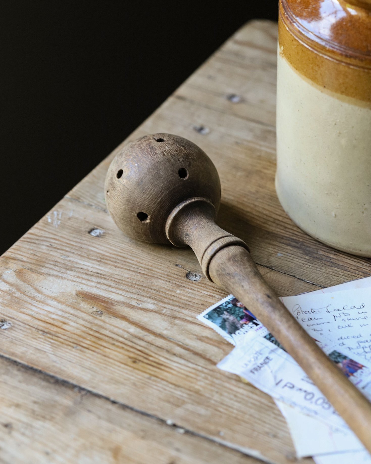Vintage olive scoop spoon on a rustic table