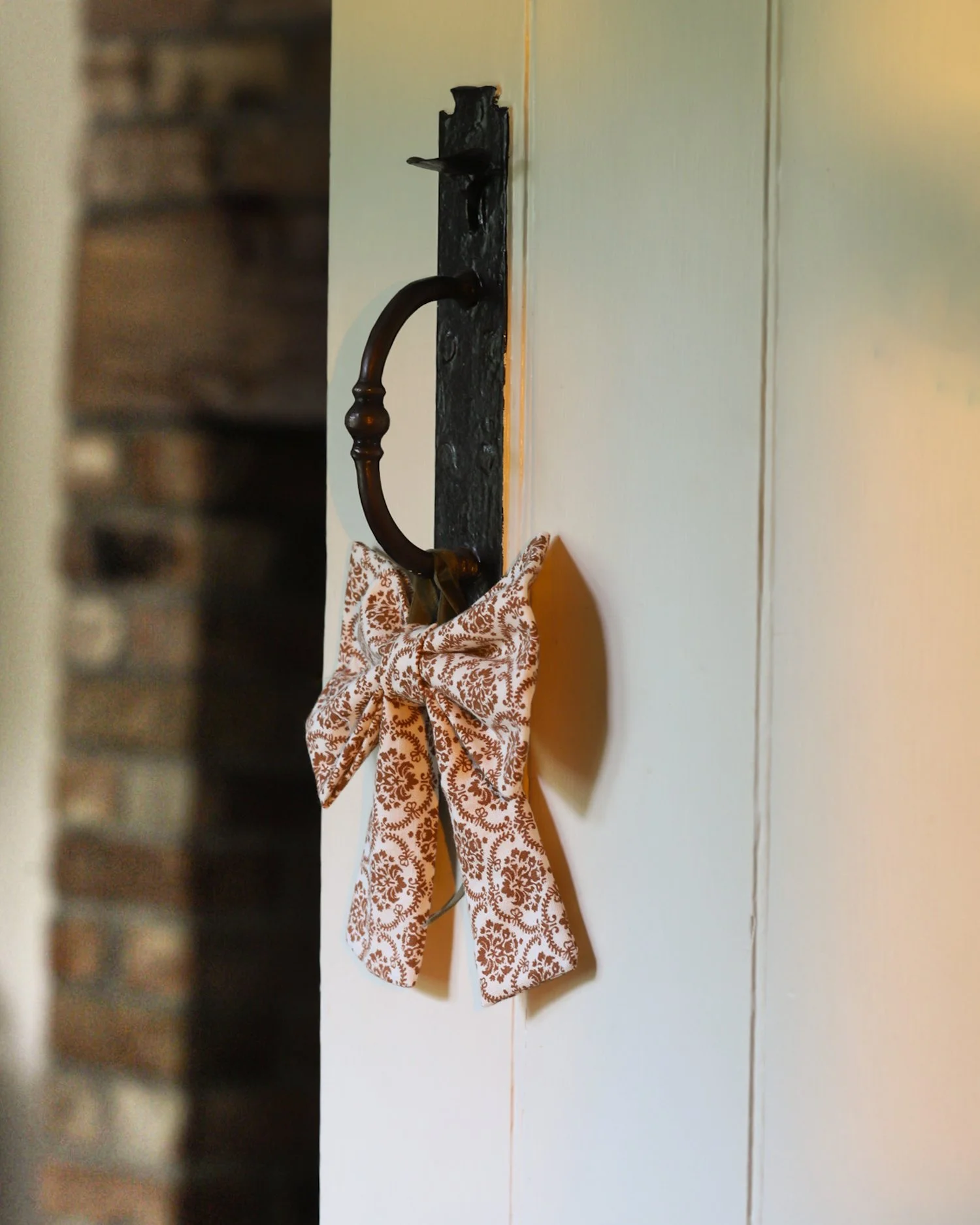A vintage print bow hung on a cottage door