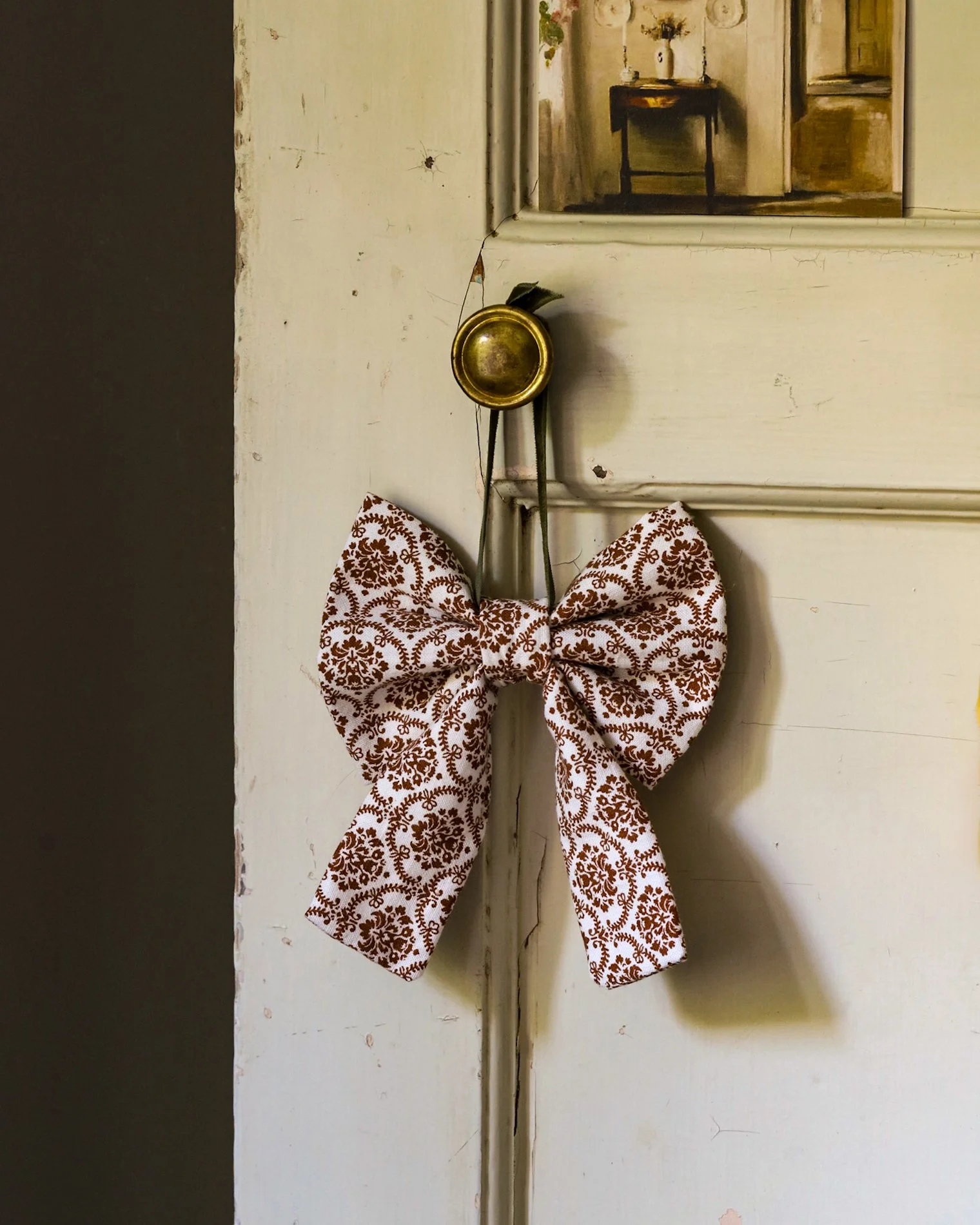 A vintage bow hung over a rustic door knob