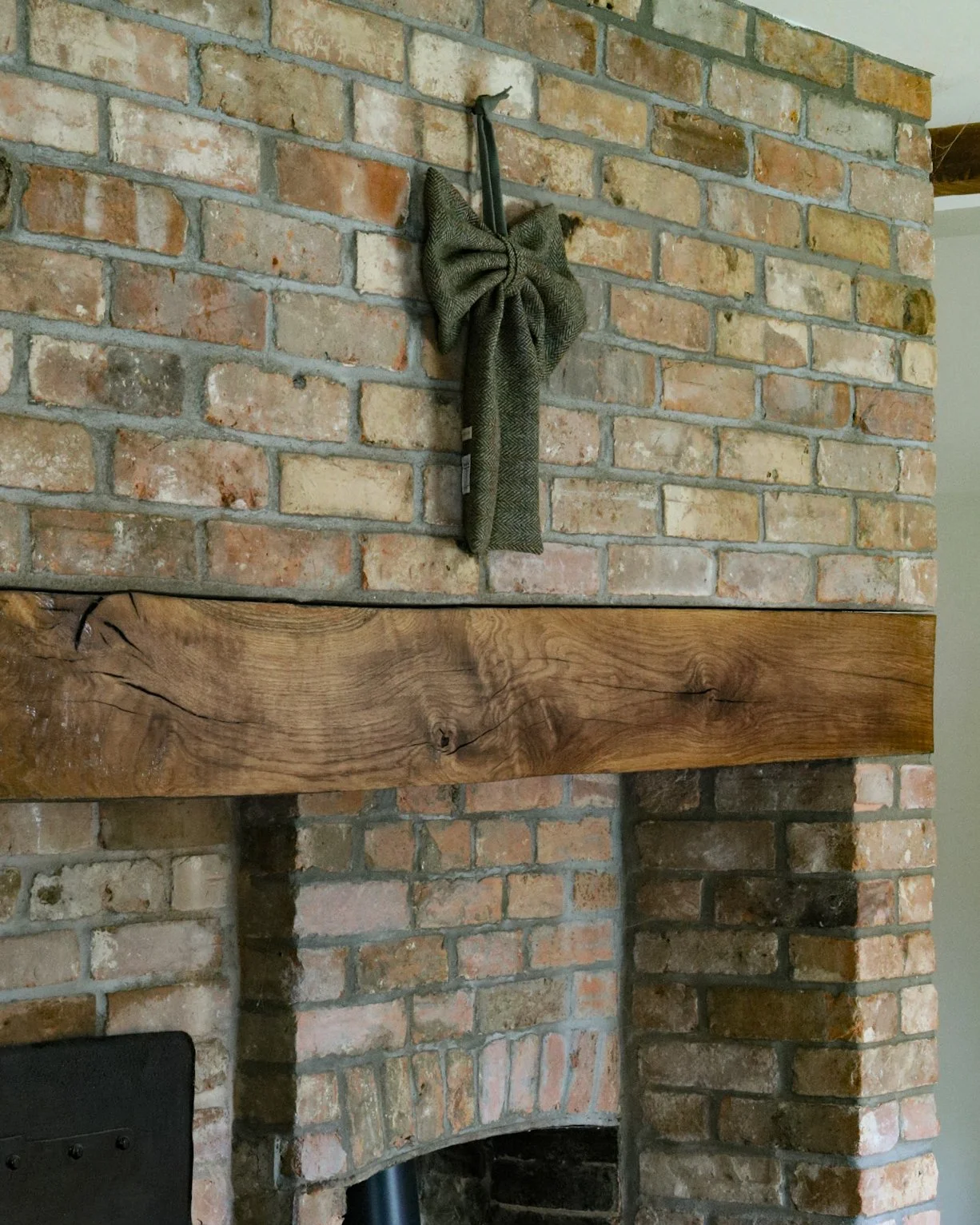 A large decorative tweed bow hanging above a fire place.