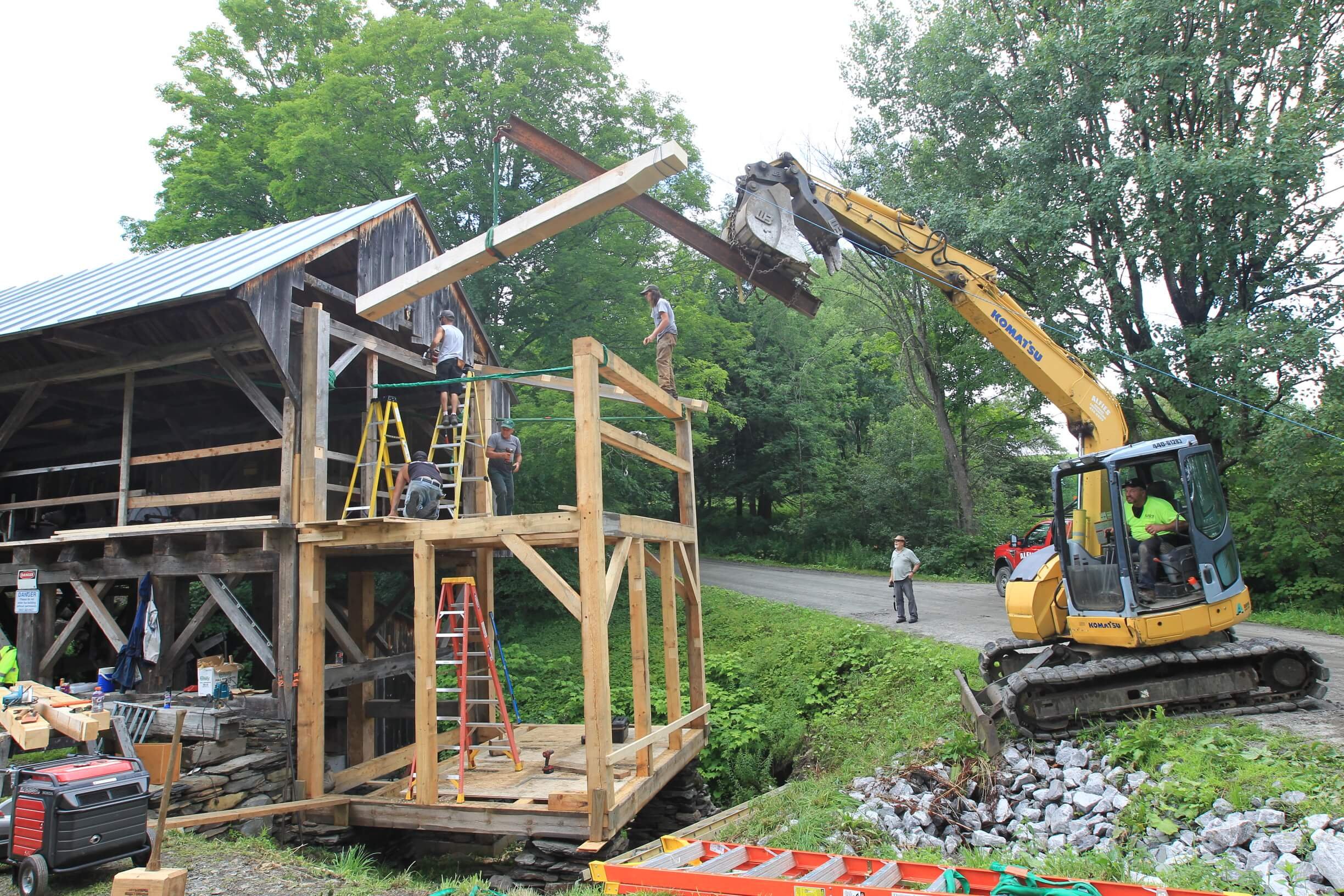 An excavator lifting a timber into place during the sawmill renovation.