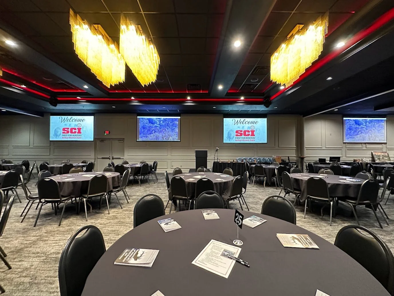Business meeting setup in a Green Bay banquet hall with tables, chairs, and presentation space.
