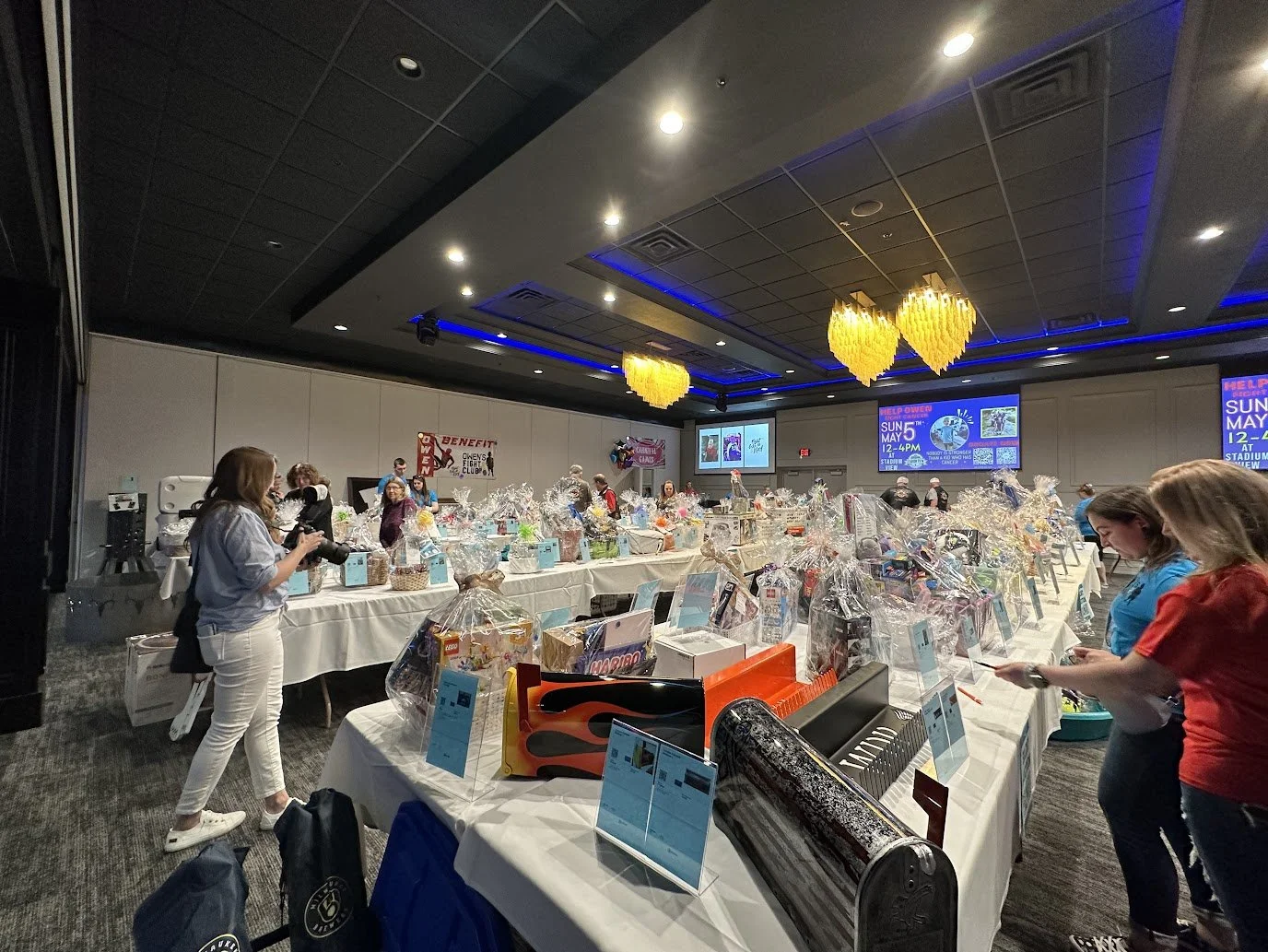 Guests browsing raffle baskets during a fundraiser event in Green Bay.