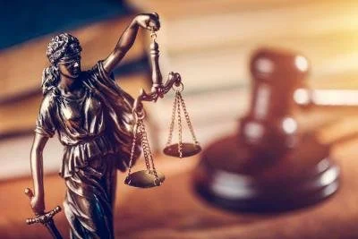 Lady justice holding scales with gavel in the background
