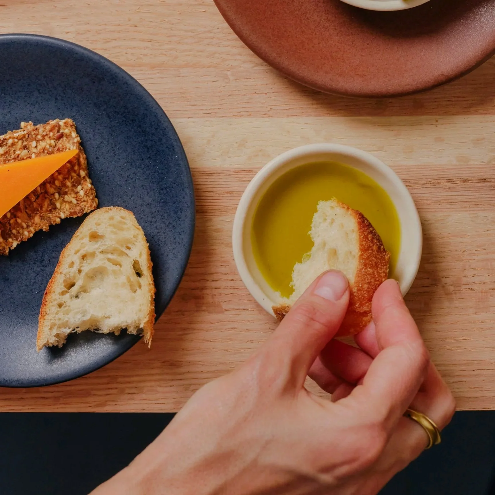 Slip-cast porcelain ramekin with handmade variation, shown in use with olive oil dipping sauce — Myrth Ceramics
