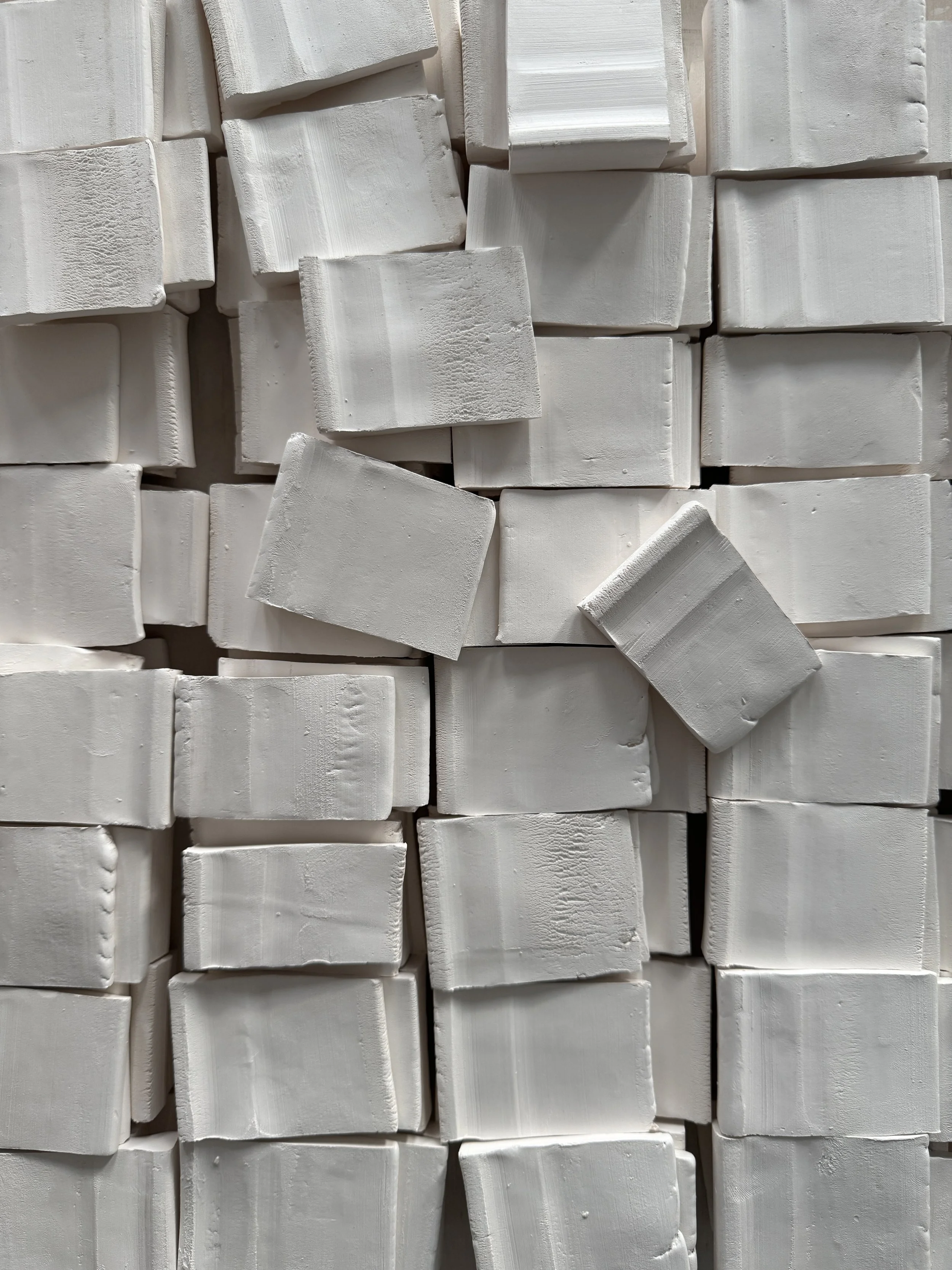 Rows of unfired glaze test tiles in the studio.