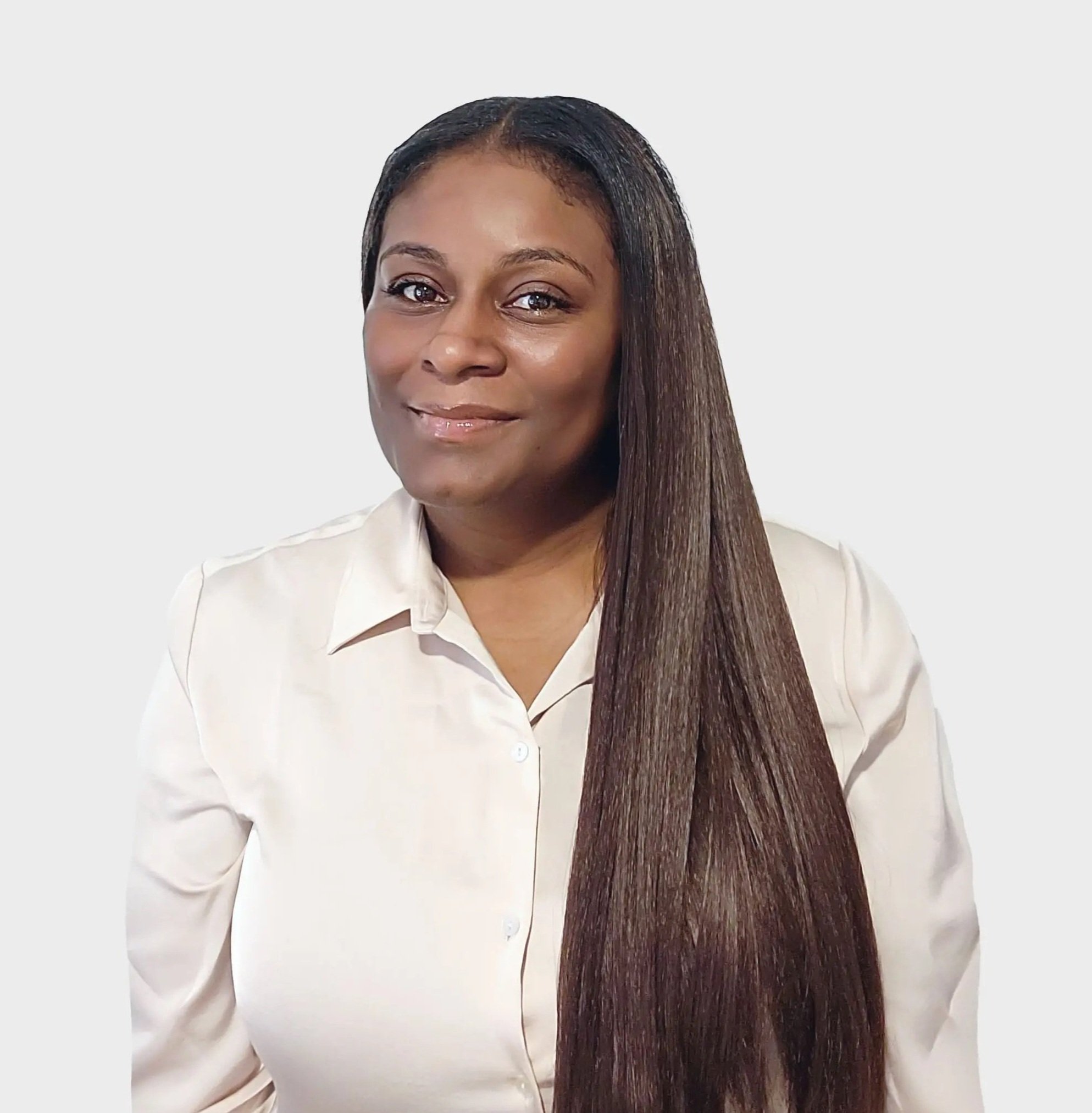 Jessica Baltazar, wearing a cream-colored blouse, smiling softly at the camera against a plain white background.