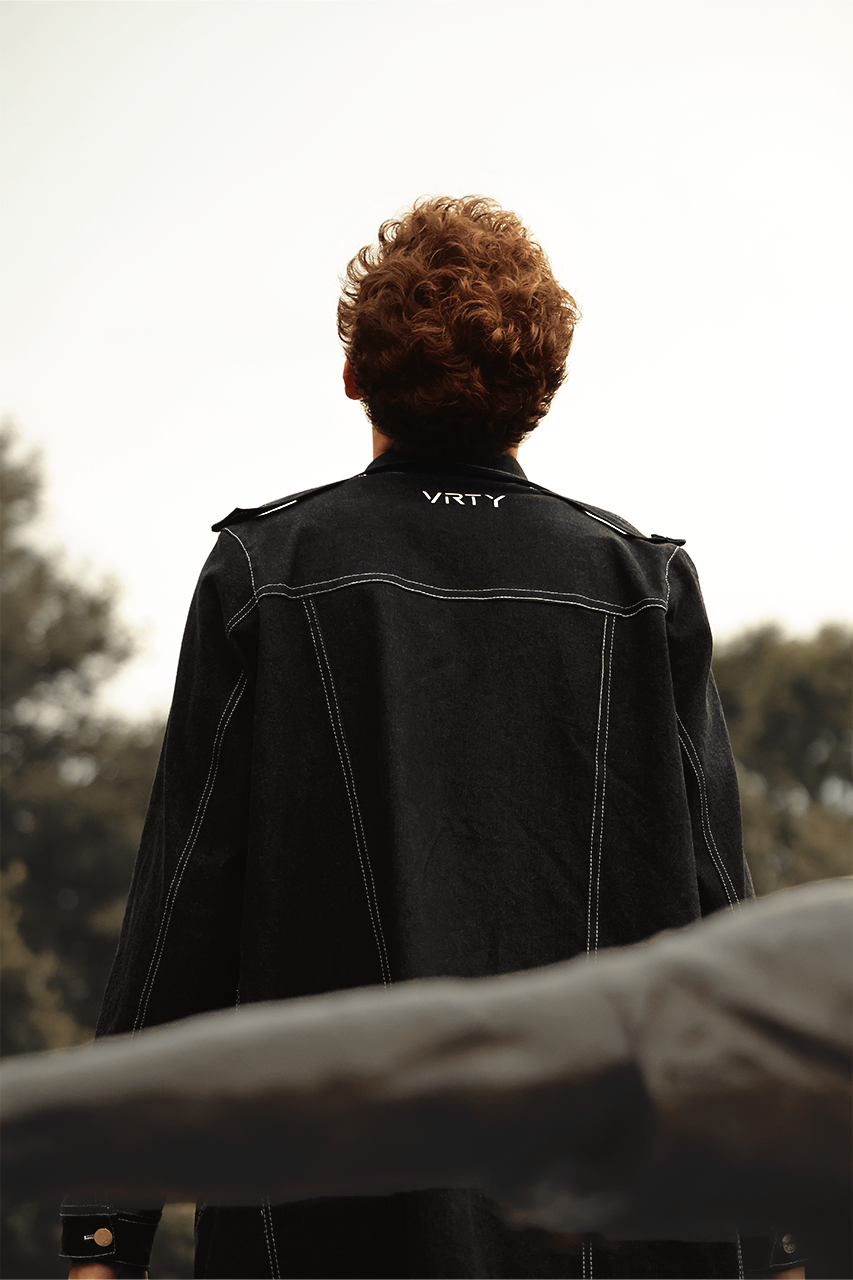 Back view of VRTY trench coat showing logo beneath neck
