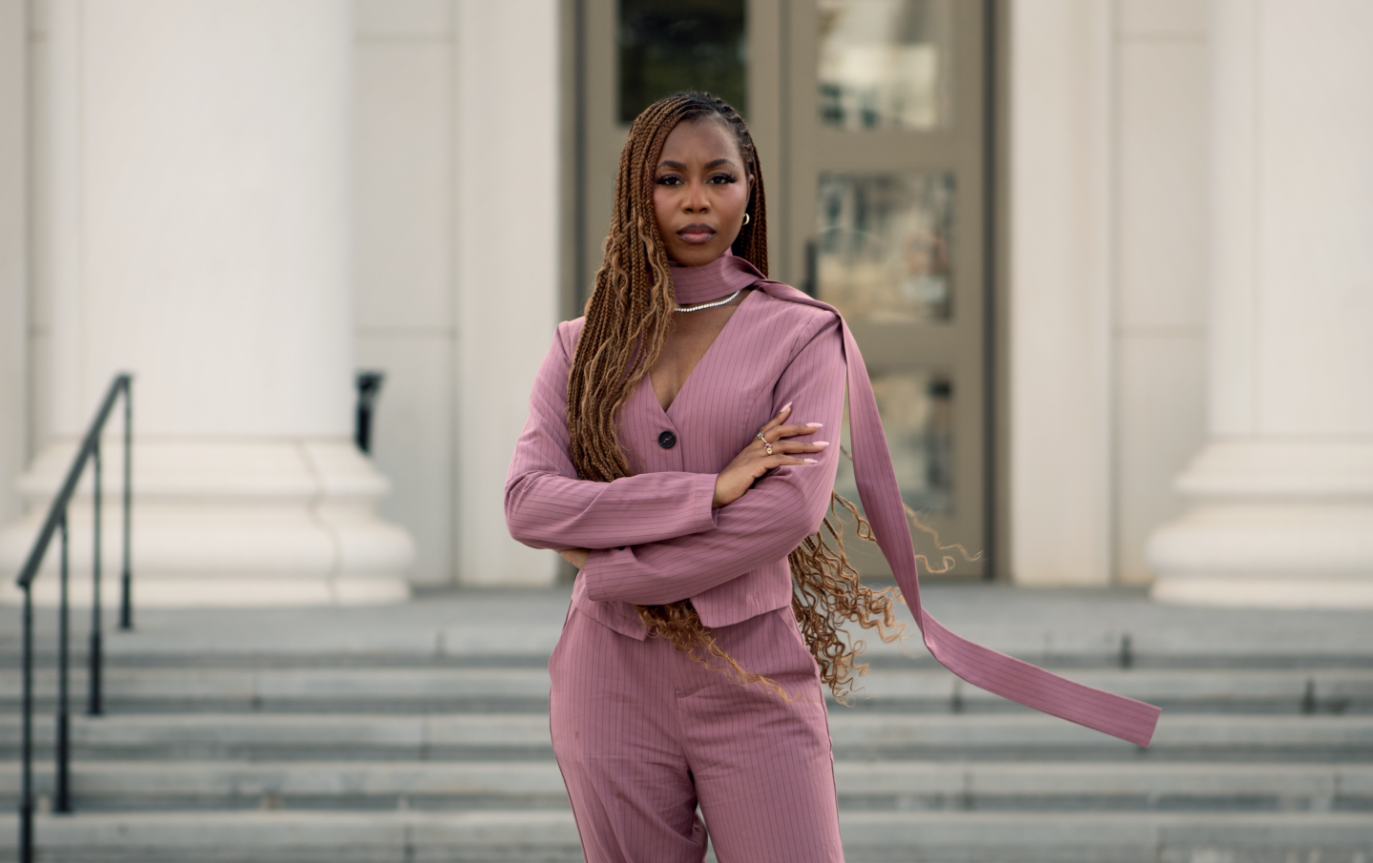 Courtney McClain standing defiantly with arms crossed in front of courthouse