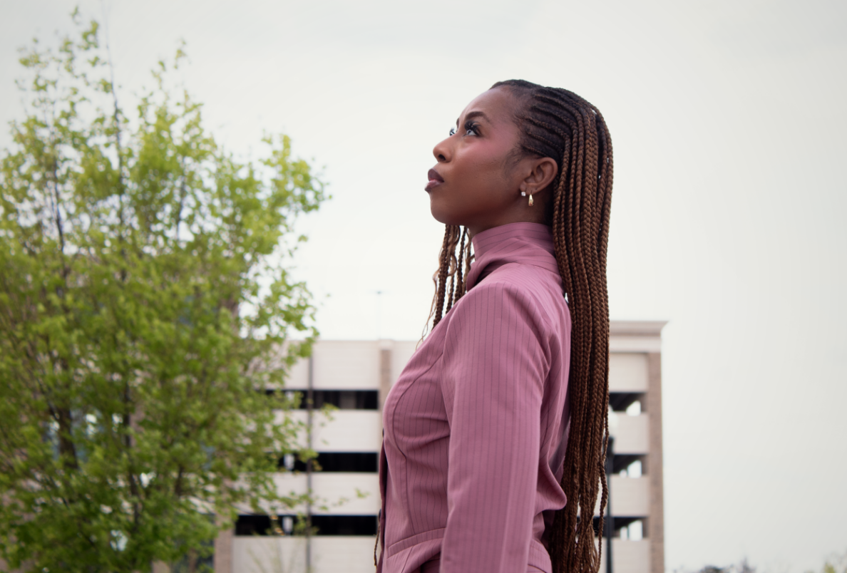 Courtney McClain wearing pink Greek sorority blazer staring up