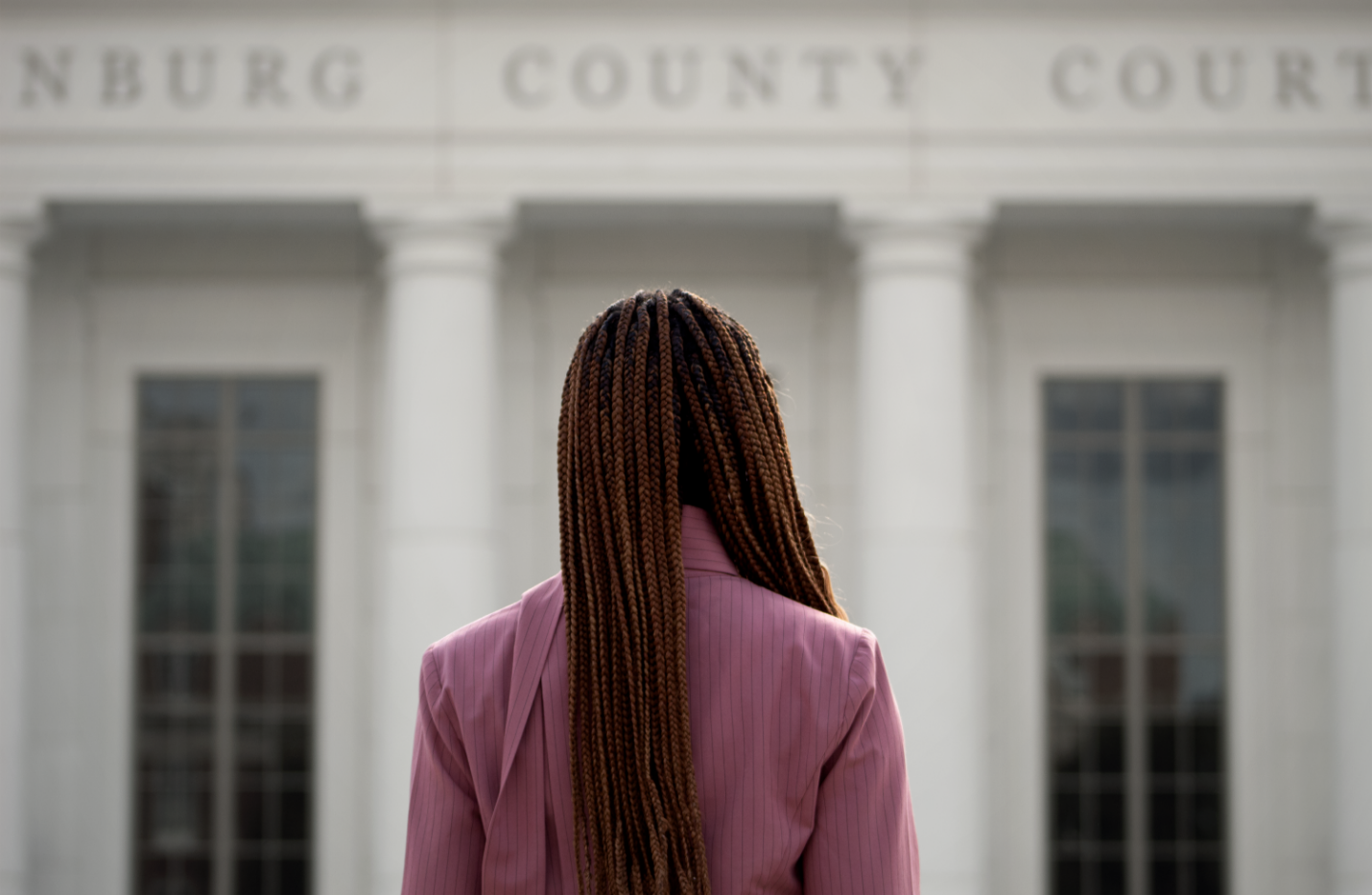 Courtney McClain back against camera, staring at judicial center