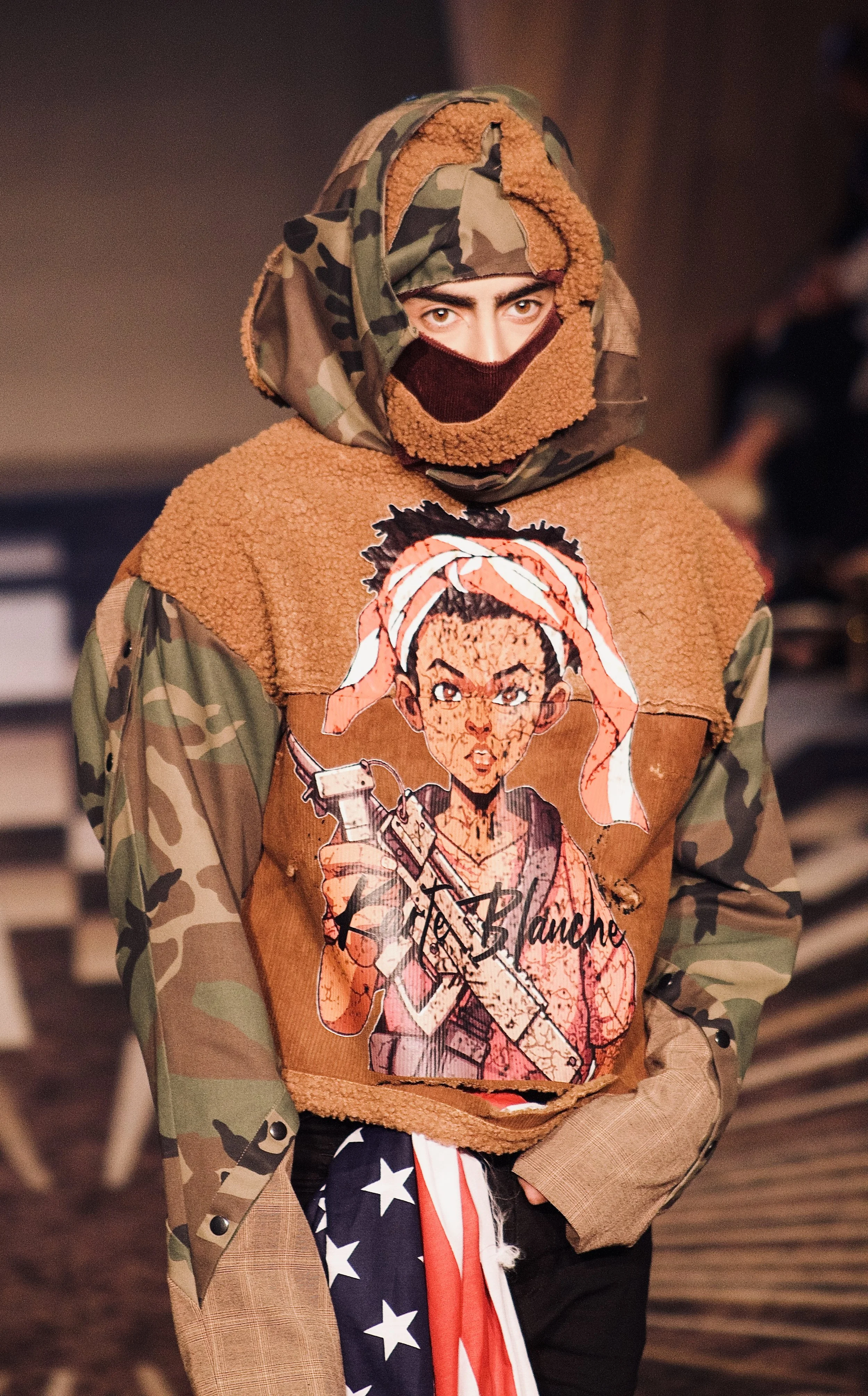 Model wearing symbolic hoodie on runway