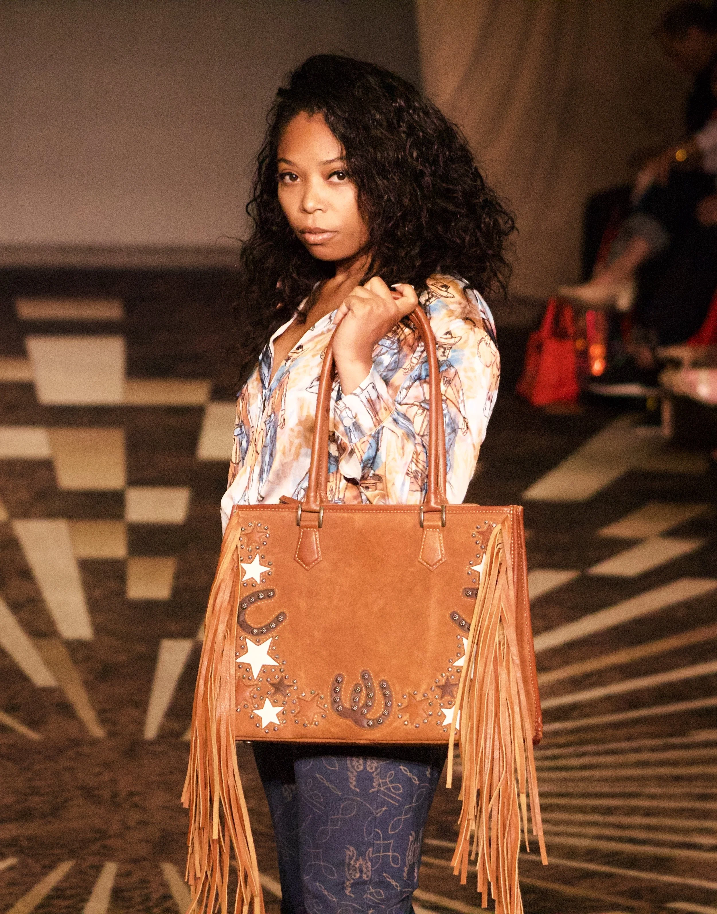 Model holding leather bag on runway