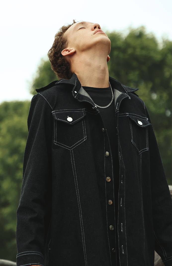 Action shot of boy wearing VRTY jacket looking up to the sky
