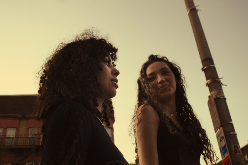 Two models in the street talking in golden hour lighting