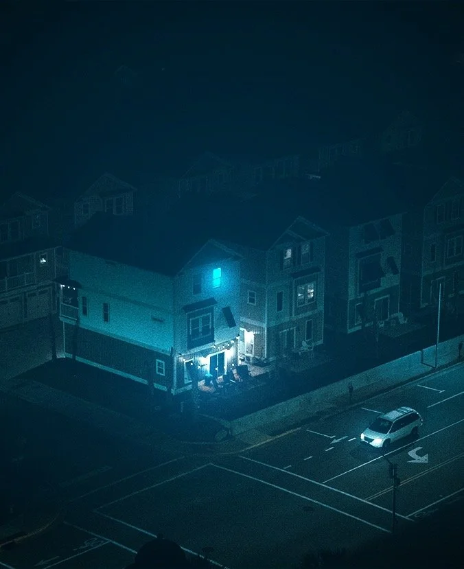 A beachfront home illuminated by glowing interior lighting in the midst of blue hour