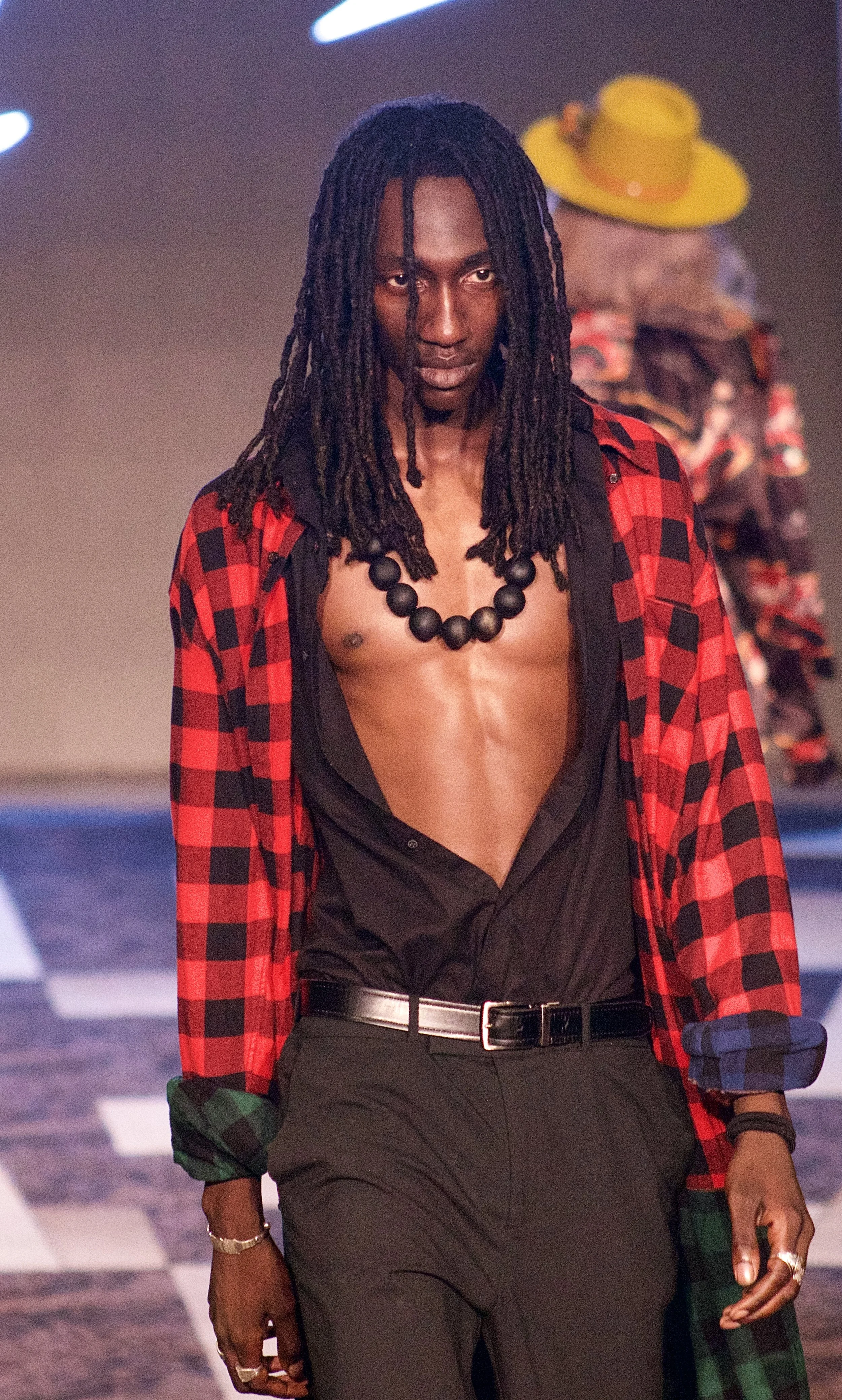 Model wearing red and black flannel top on runway