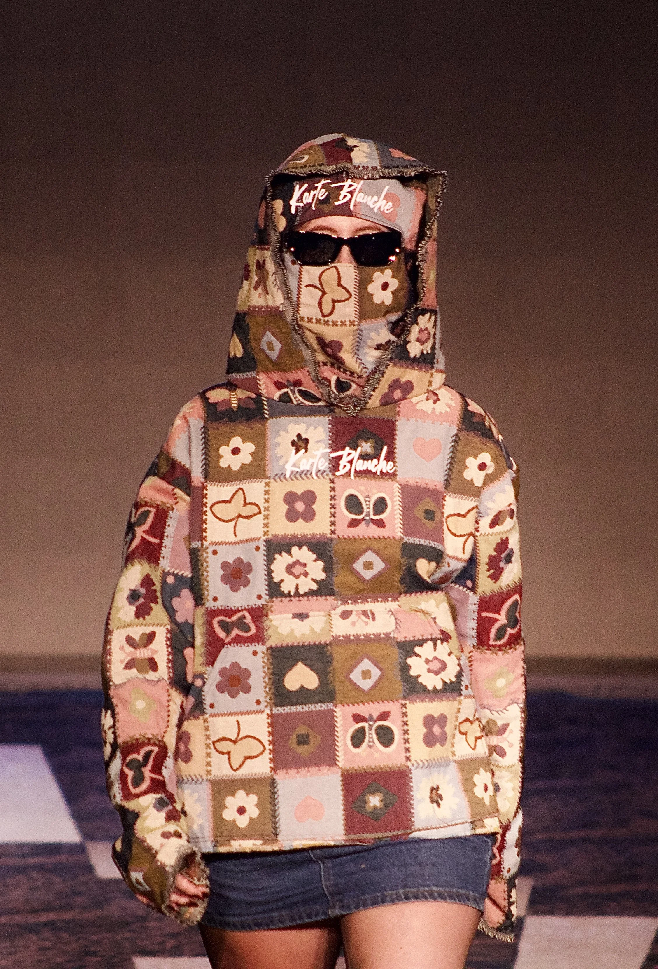 Model wearing Karte Blanche hoodie on runway