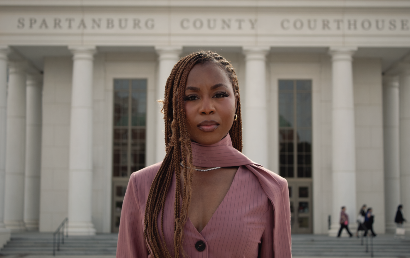 Courtney McClain staring at camera in front of Spartanburg County Courthouse