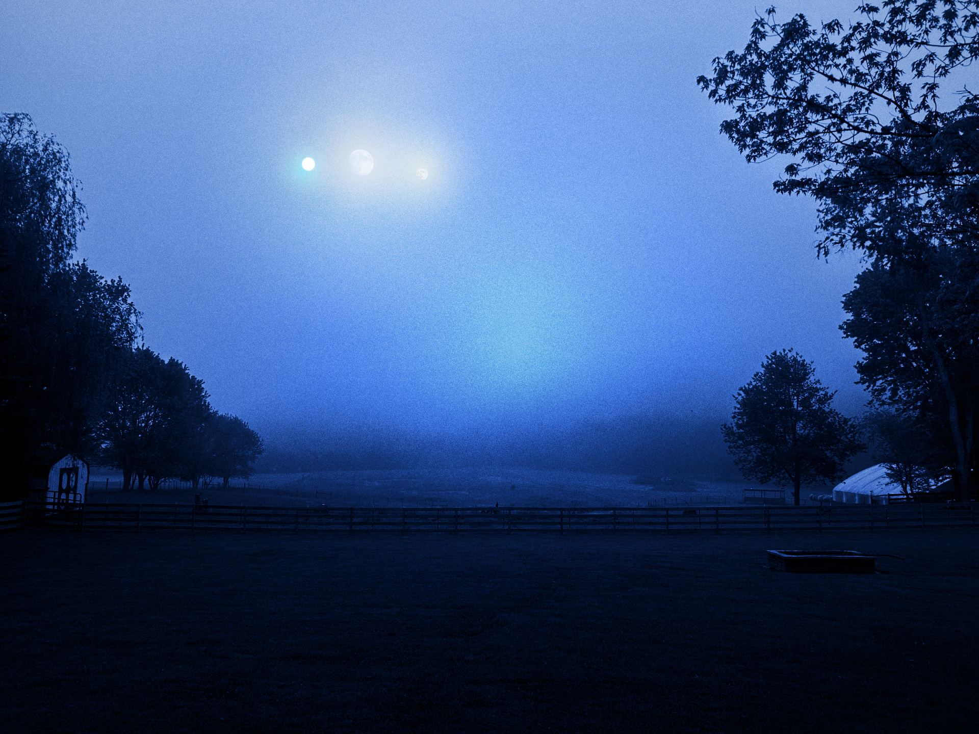A rural landscape with three glowing moons in the midst of blue hour lighting