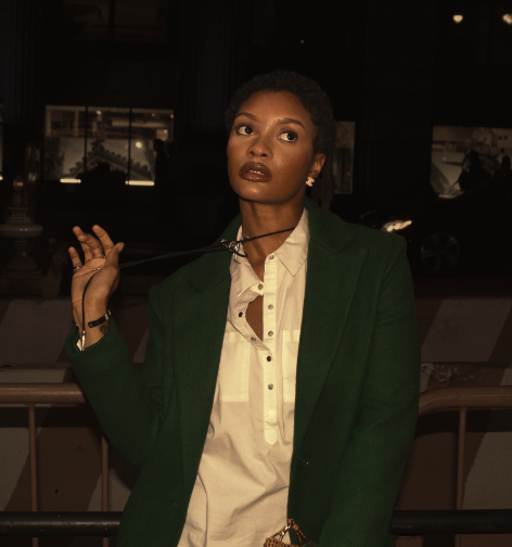 Model wearing green blazer in dim lighting posing