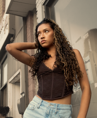 Model posing beside storefront