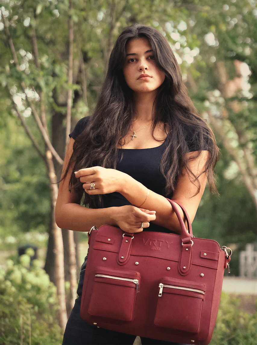 Young lady holding a VRTY briefcase in the park