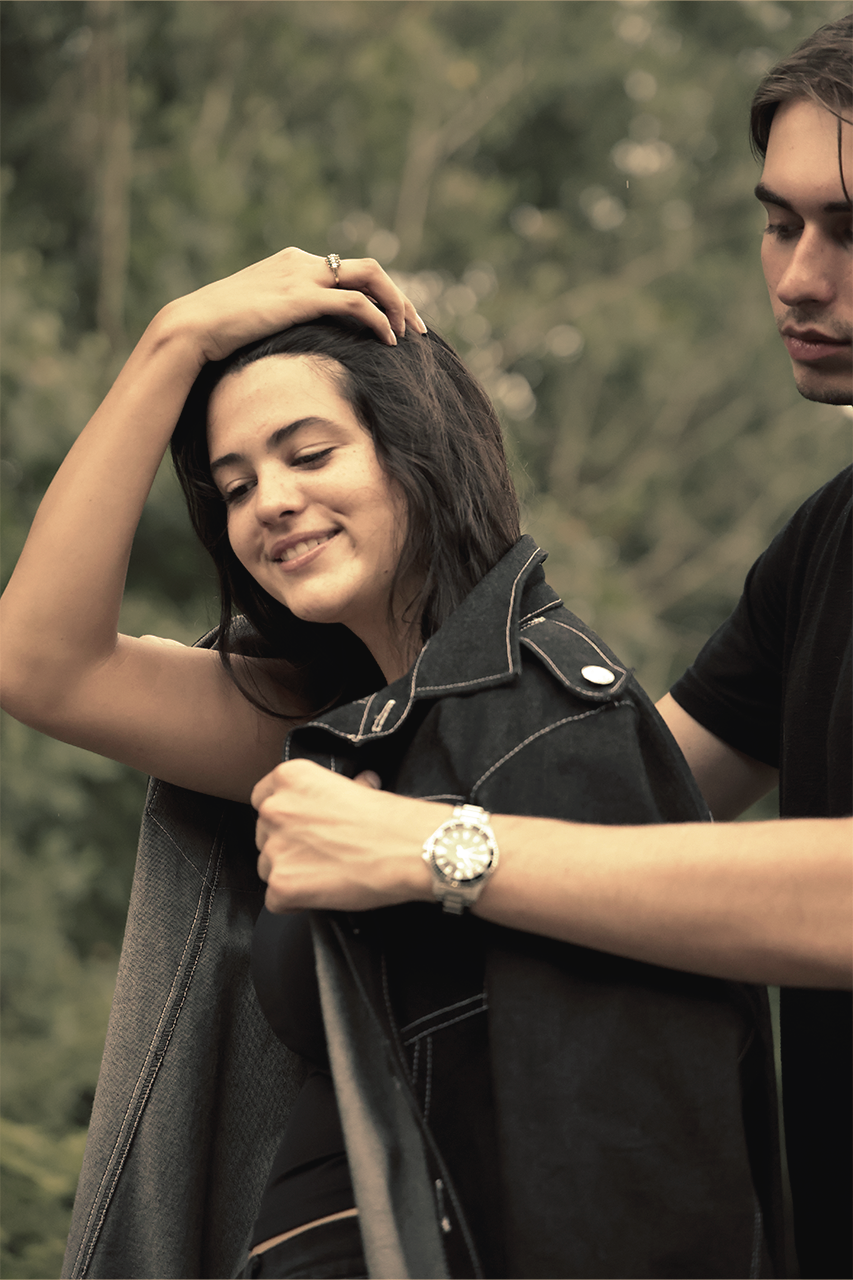 Man placing coat over his partner's shoulders