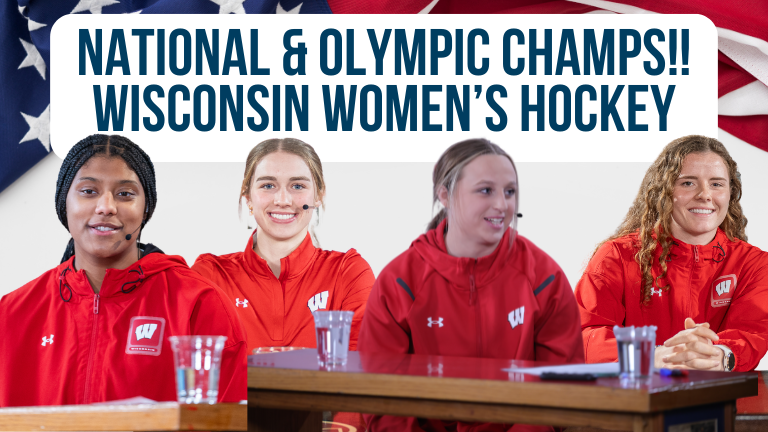 Four Wisconsin women's hockey players sitting at a table during a press conference, wearing red team jackets with Wisconsin logo, with glasses of water in front of them.
