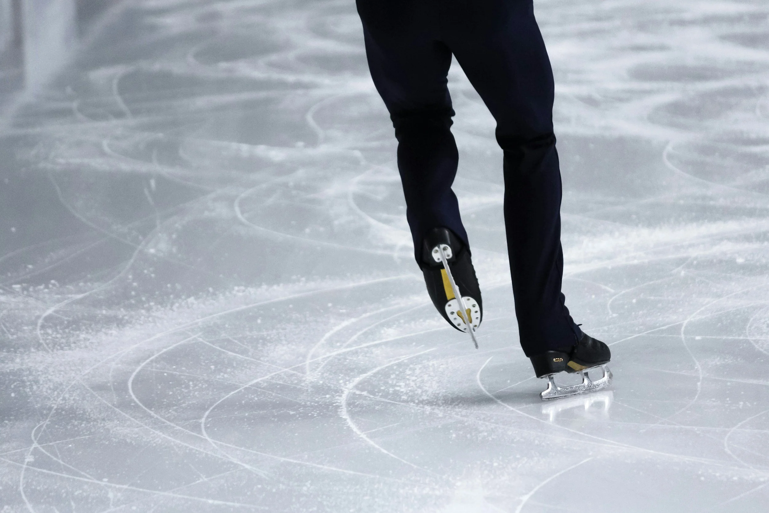 A figure skater skates away down the ice