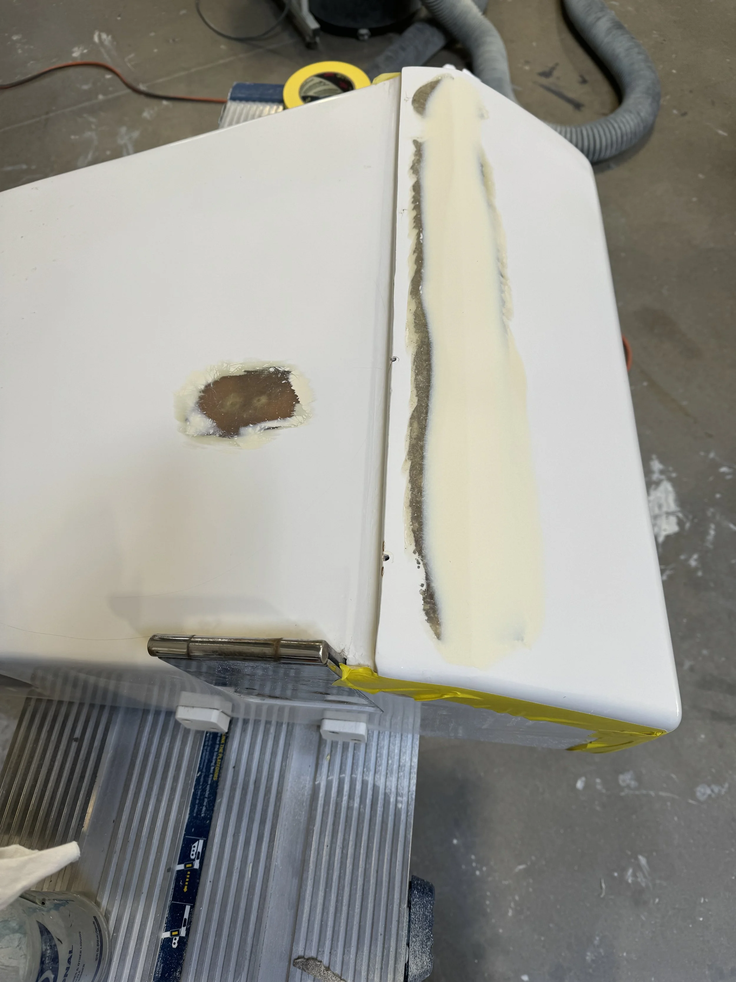 Tuna door repair on a boat: damaged fiberglass removed, new fiberglass applied, gelcoat sprayed, and finishing completed
