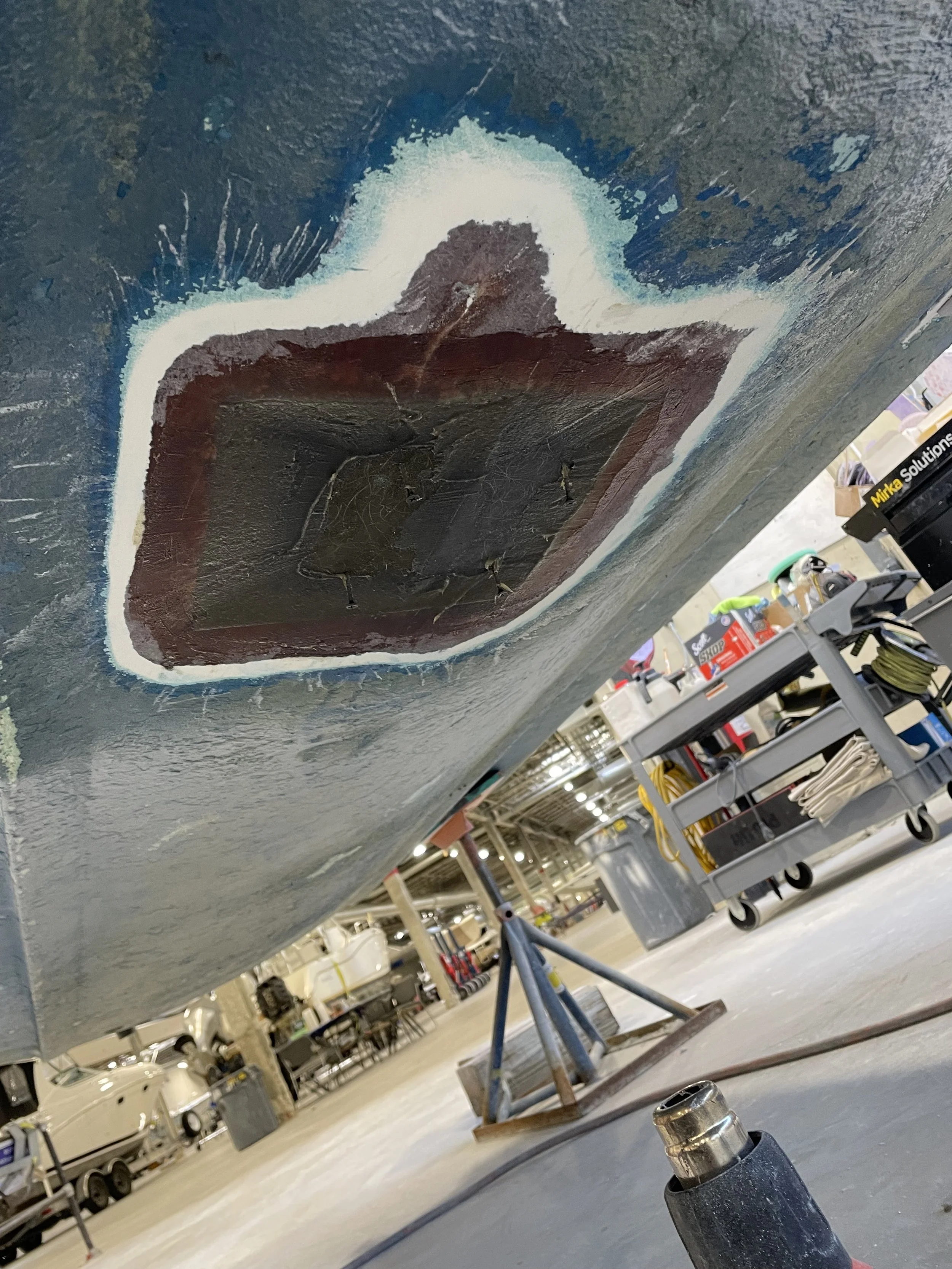 Keel repair on a boat: damaged fiberglass removed, new fiberglass applied, and fresh gelcoat for bottom paint