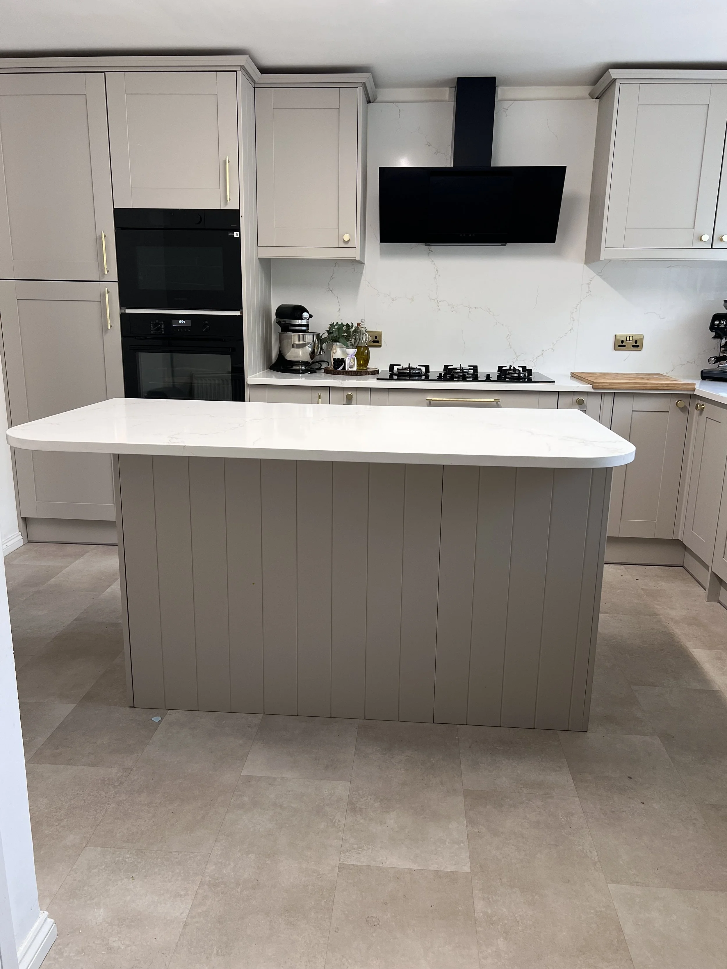 Soft stone Shaker kitchen with pale quartz worktops and a generous central island