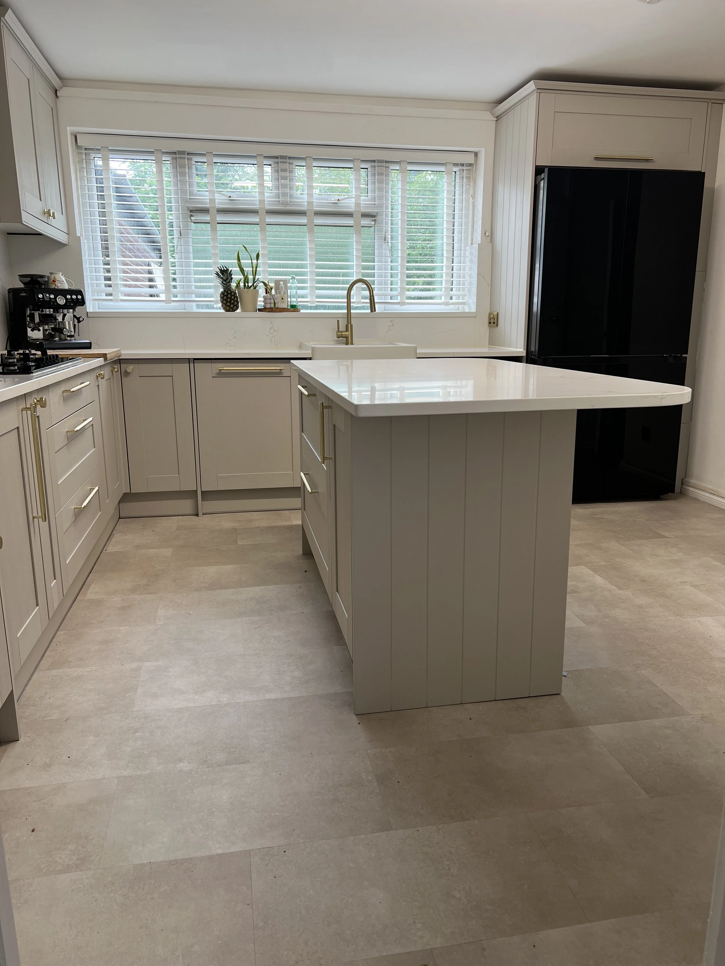 Soft stone Shaker kitchen with pale quartz worktops and a central island