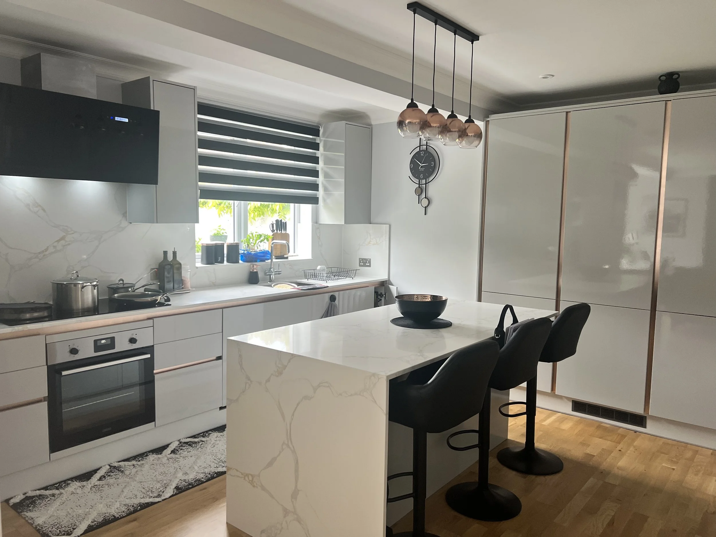 Wide view of a compact contemporary pearl kitchen with concealed storage