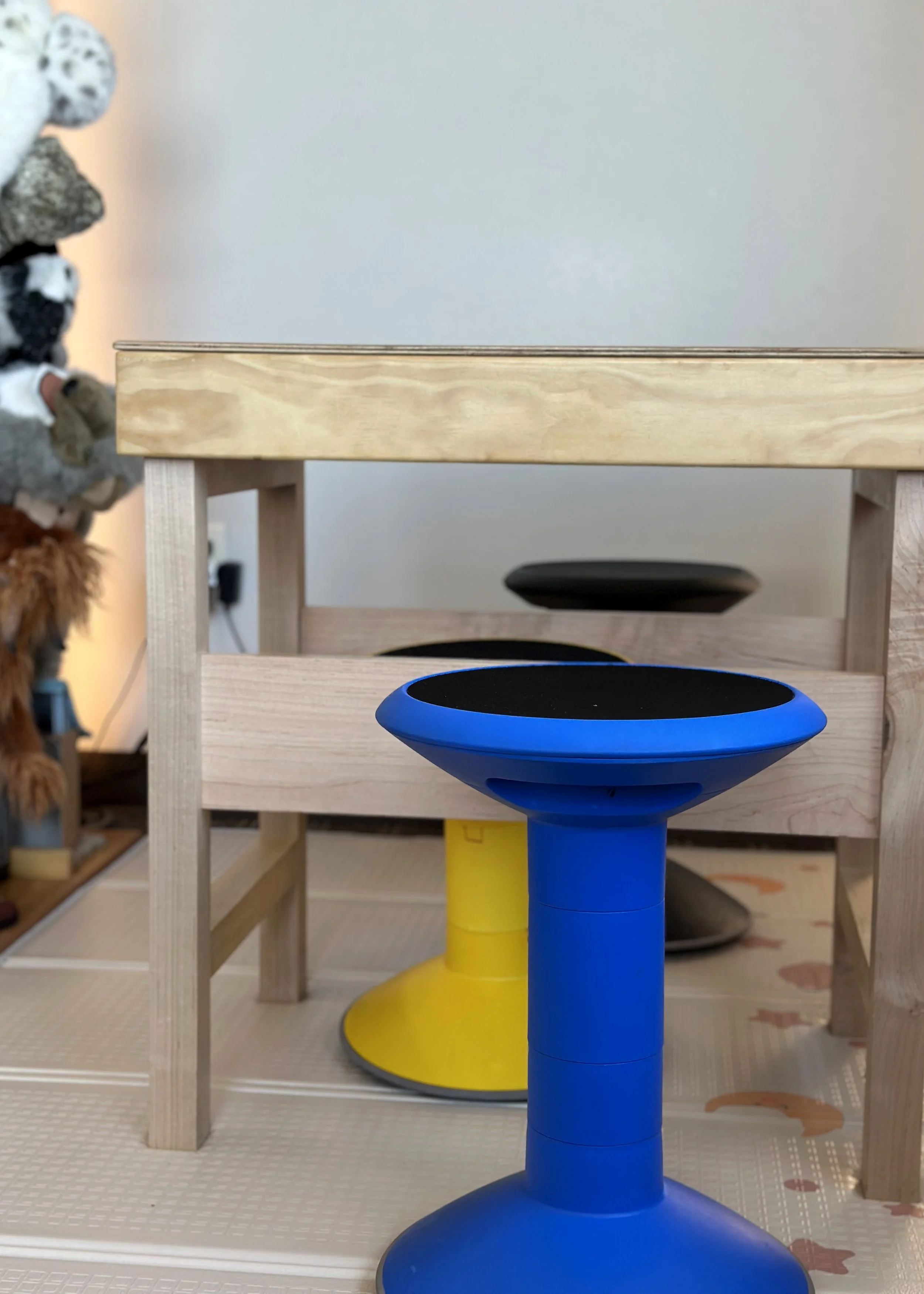 A blue and yellow chair beside a wooden table