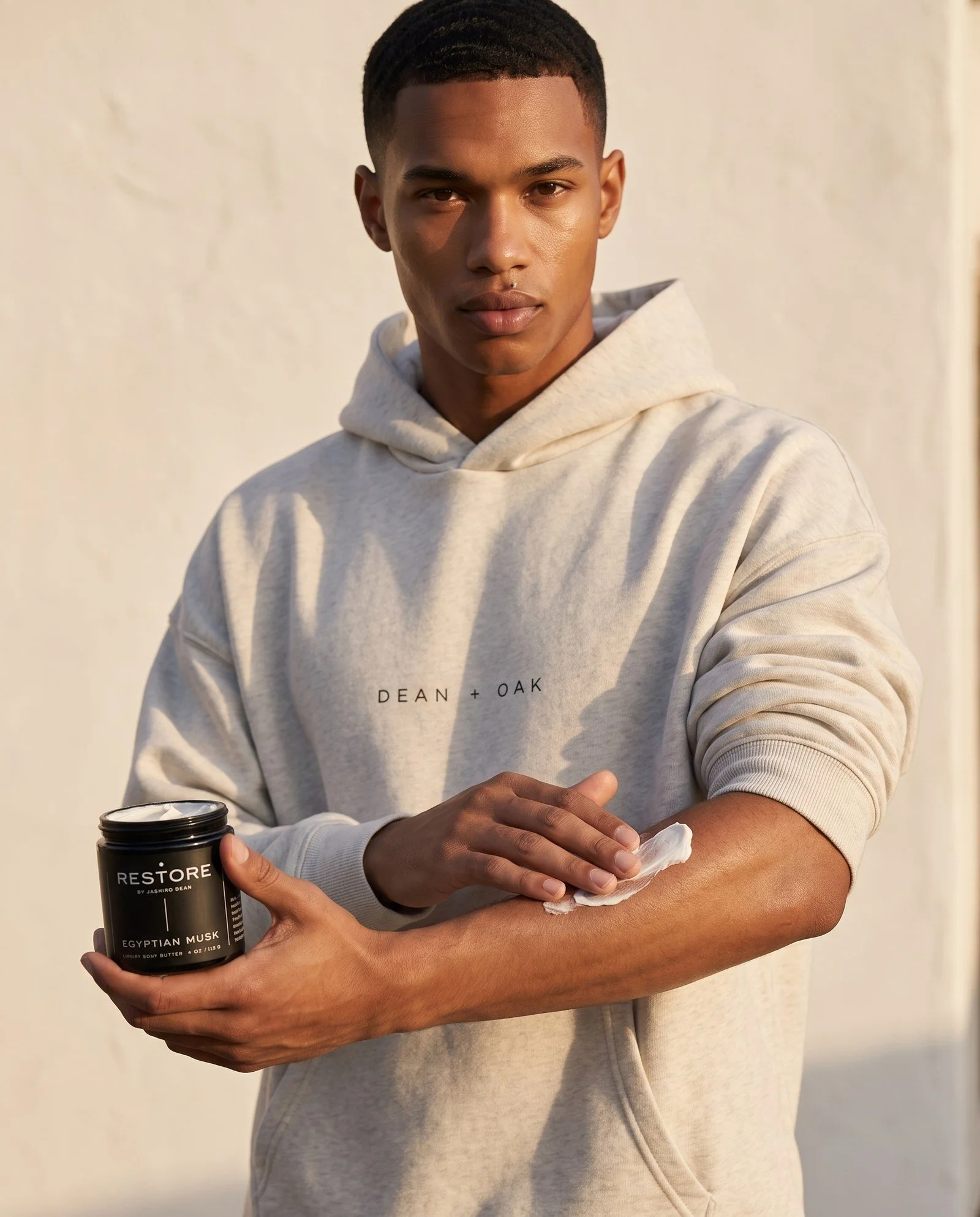 Dean + Oak RESTORE Egyptian Musk Body Butter, held by a model