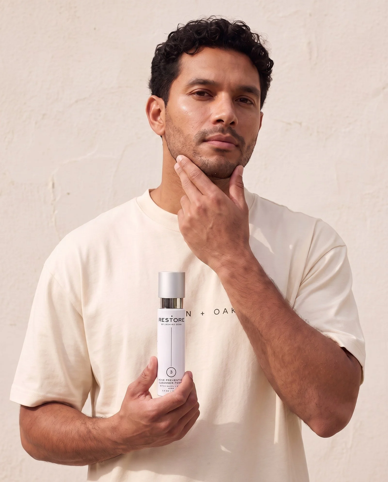Dean + Oak RESTORE Acne Prevention Cleanser-Toner, held by a model