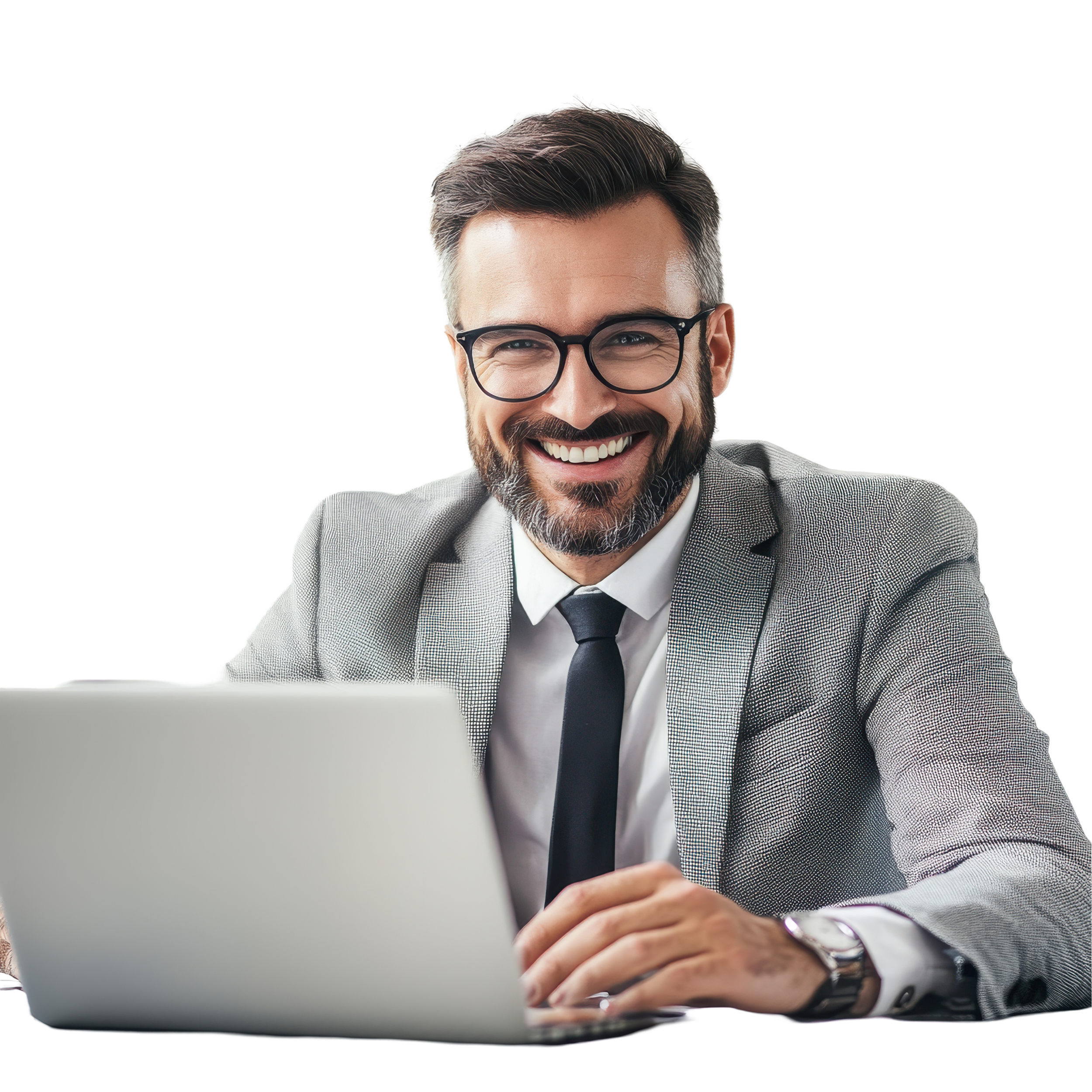 A man with styled hair and glasses smiling in front of a laptop, dressed in a gray suit jacket, white shirt, and dark tie.